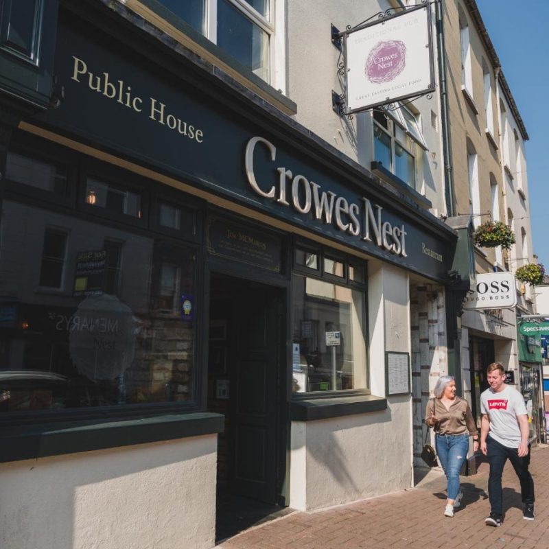 a group of people walking in front of a store