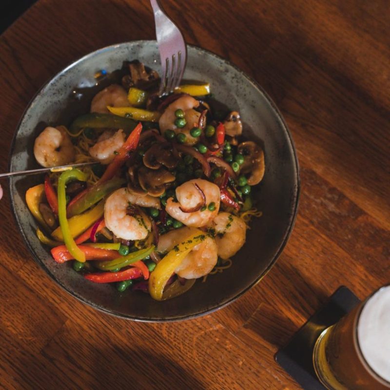 a bowl of food sitting on top of a wooden table