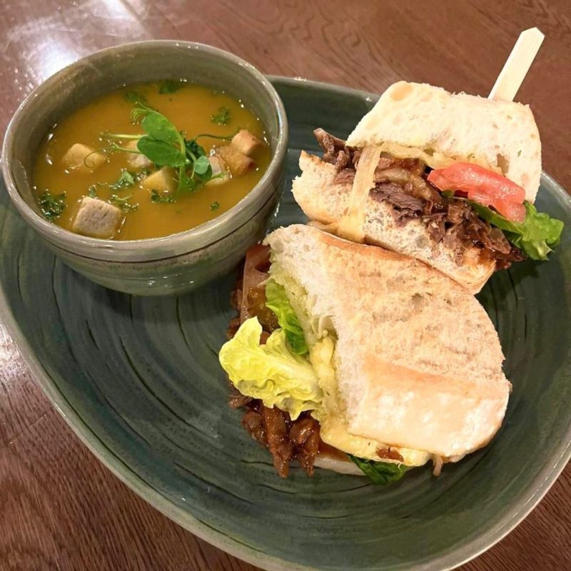 a bowl of soup and a sandwich on a plate