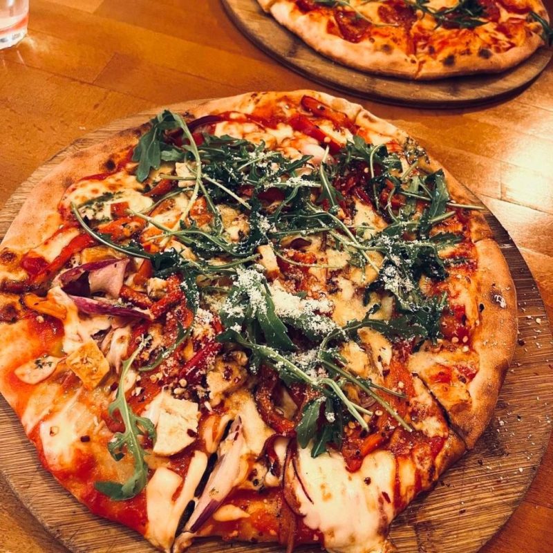 a pizza sitting on top of a wooden table